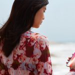 Frau am Strand mit iPhone X