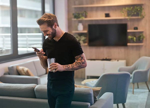 Mann mit Smartphone im Wohnzimmer