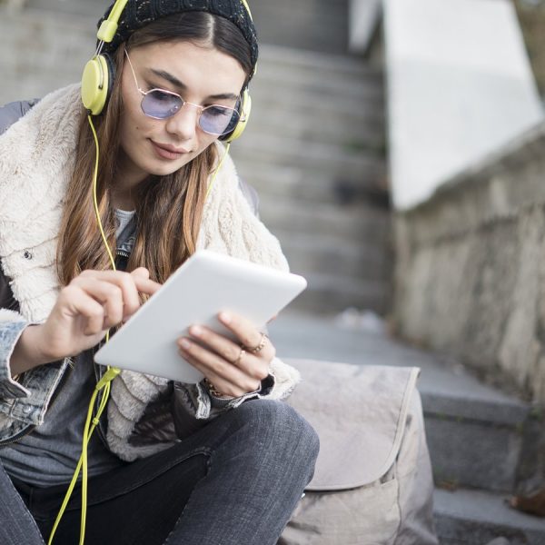 Junges Mädchen ergänzt auf Tablet Songs für gemeinsame Spotify-Playlist