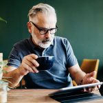 Eine Person sitzt in einem Café und bedient ihr iPad.