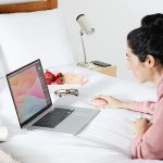 Eine Person nutzt eine Logitech MX Anywhere 3 an einem Laptop auf dem Bett.