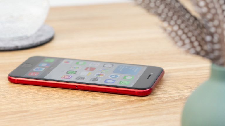 Das iPhone SE 2020 liegt mit eingeschaltetem Display auf einem Tisch.