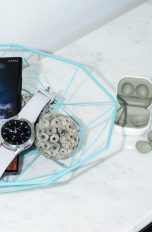 Ein Samsung Galaxy S22 Ultra liegt in einer Schale neben einer Galaxy Watch4 und zwei Paar Galaxy Buds.