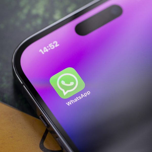 Nahaufnahme eines iPhone 14 Pro, auf dessen Display die WhatsApp-App zu sehen ist.