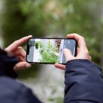 Eine Person hält ein iPhone in der Hand und macht ein Live Photo einer Pflanze.