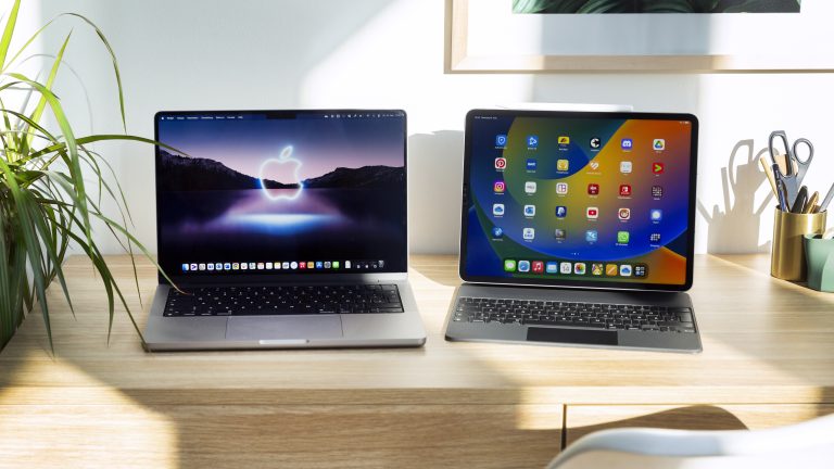 Ein MacBook steht neben einem iPad Pro auf einem Schreibtisch.