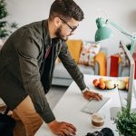 Eine Person stützt die Hände auf einen Schreibtisch, auf dem ein Mac steht.