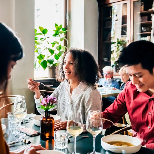 Mehrere Personen sitzen in einem Restaurant an einem Tisch und essen.