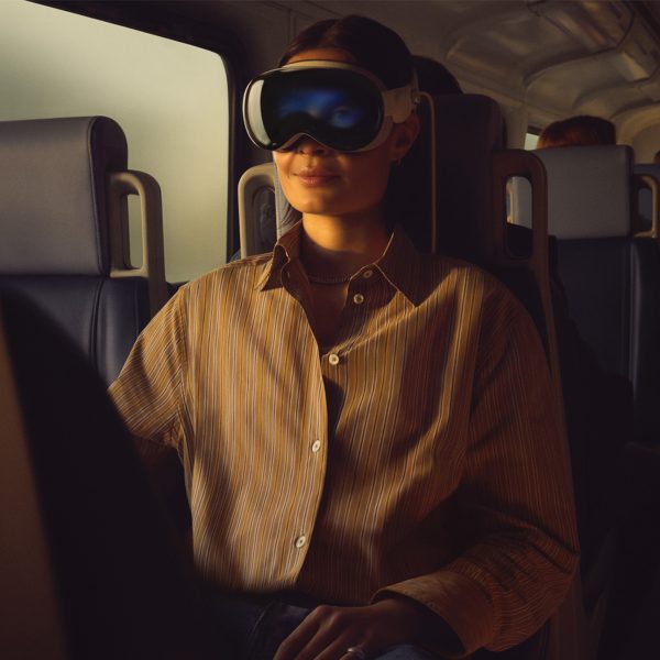 Eine Person mit einer Apple Vision Pro sitzt in einem Zug.
