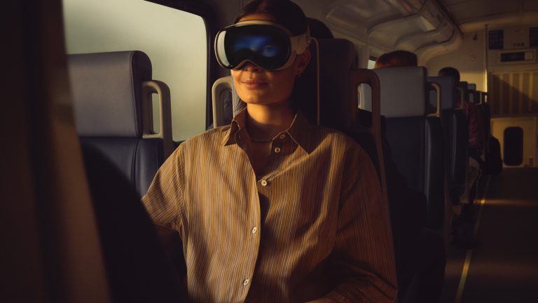 Eine Person mit einer Apple Vision Pro sitzt in einem Zug.