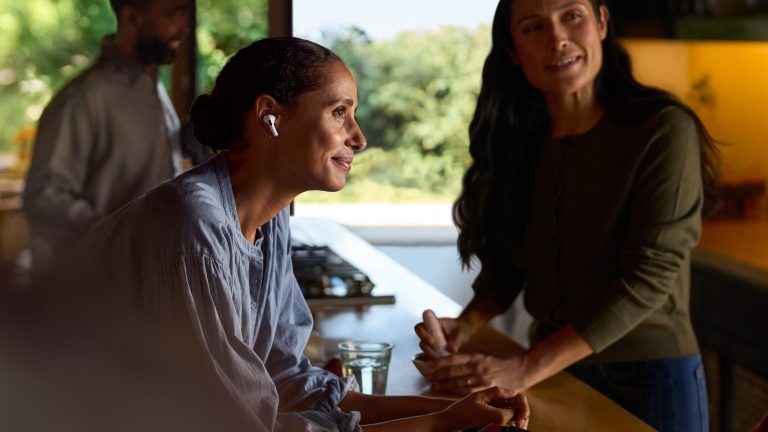 Eine Person unterhält sich in der Küche mit einer anderen Person und trägt AirPods Pro 2.