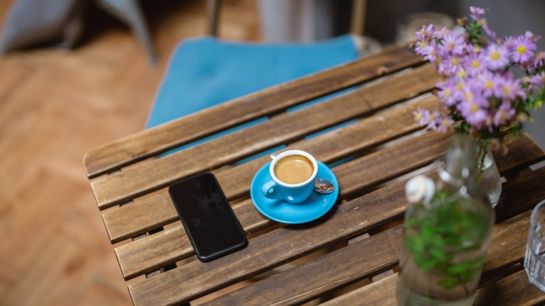 Ein Smartphone liegt auf einem Tisch in einem Café.