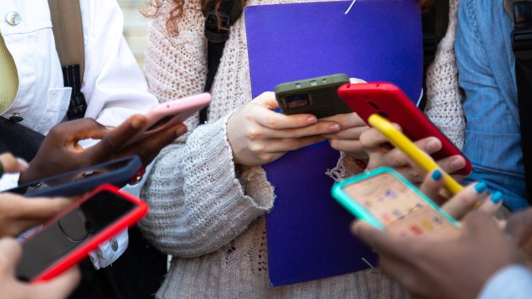 Mehrere Personen halten ihre Smartphones in unterschiedlichen Schutzhüllen nebeneinander.