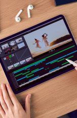 Eine Person sitzt vor einem iPad und hält einen Apple Pencil in der Hand. Auf dem Display ist eine App für Videoschnitt zu sehen.