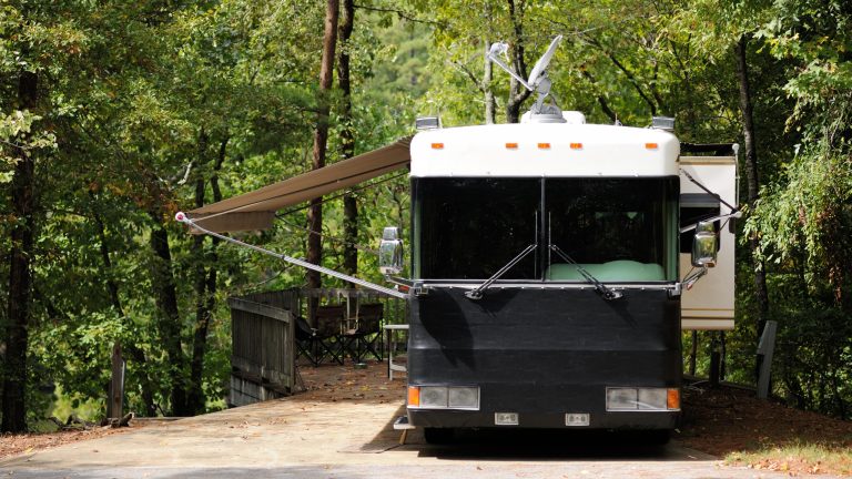 Eine Satellitenschüssel ist gen Himmel auf einem Camper montiert.