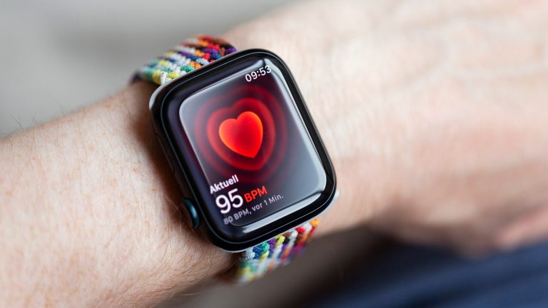 Eine Person trägt eine Apple Watch mit einem bunten Armband.