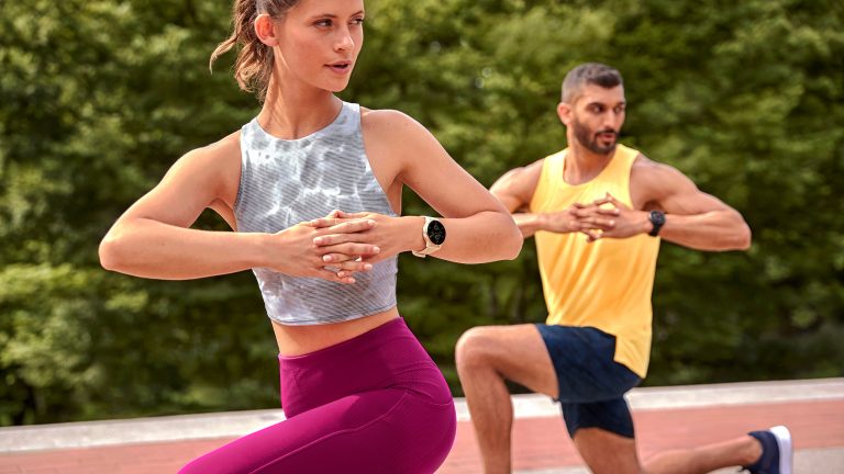 Zwei Personen in Sportoutfits machen einen Ausfallschritt.