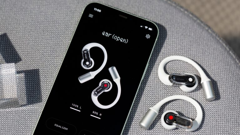 Zwei Nothing Ear (open) liegen neben einem Smartphone, auf dem die Nothing X App geöffnet ist.